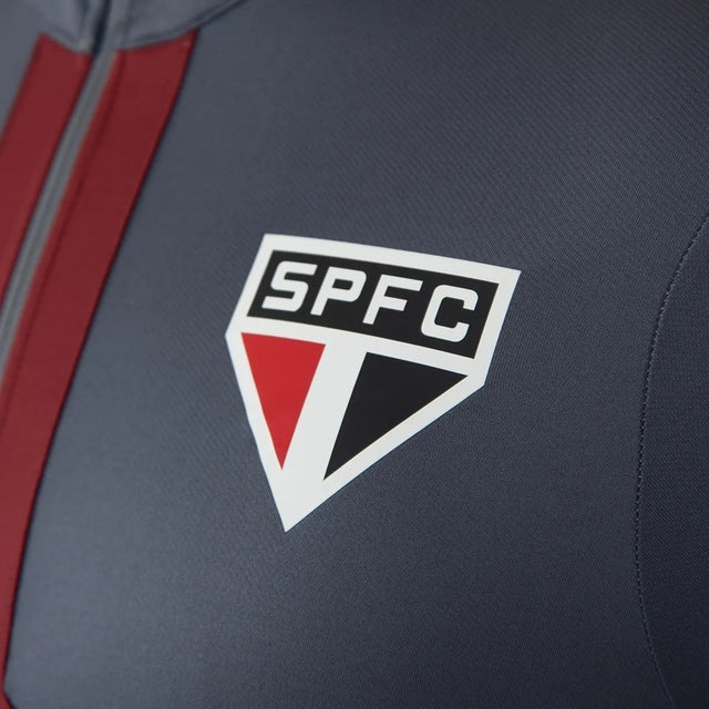 Jaqueta Corta-Vento São Paulo 25/26 - Masculina New Balance - Cinza com detalhes em vermelho