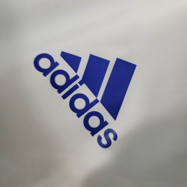 Jaqueta Corta-Vento Real Madrid 2023 - Masculina Adidas - Branca com detalhes em azul