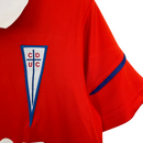 Kit Infantil Universidad Católica II Under Armour 23/24 - Vermelho com detalhes em azul e branco